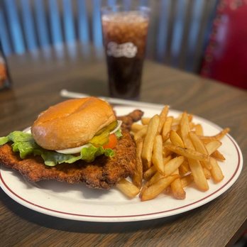 A crispy, golden-brown breaded pork tenderloin sandwich from Dino's